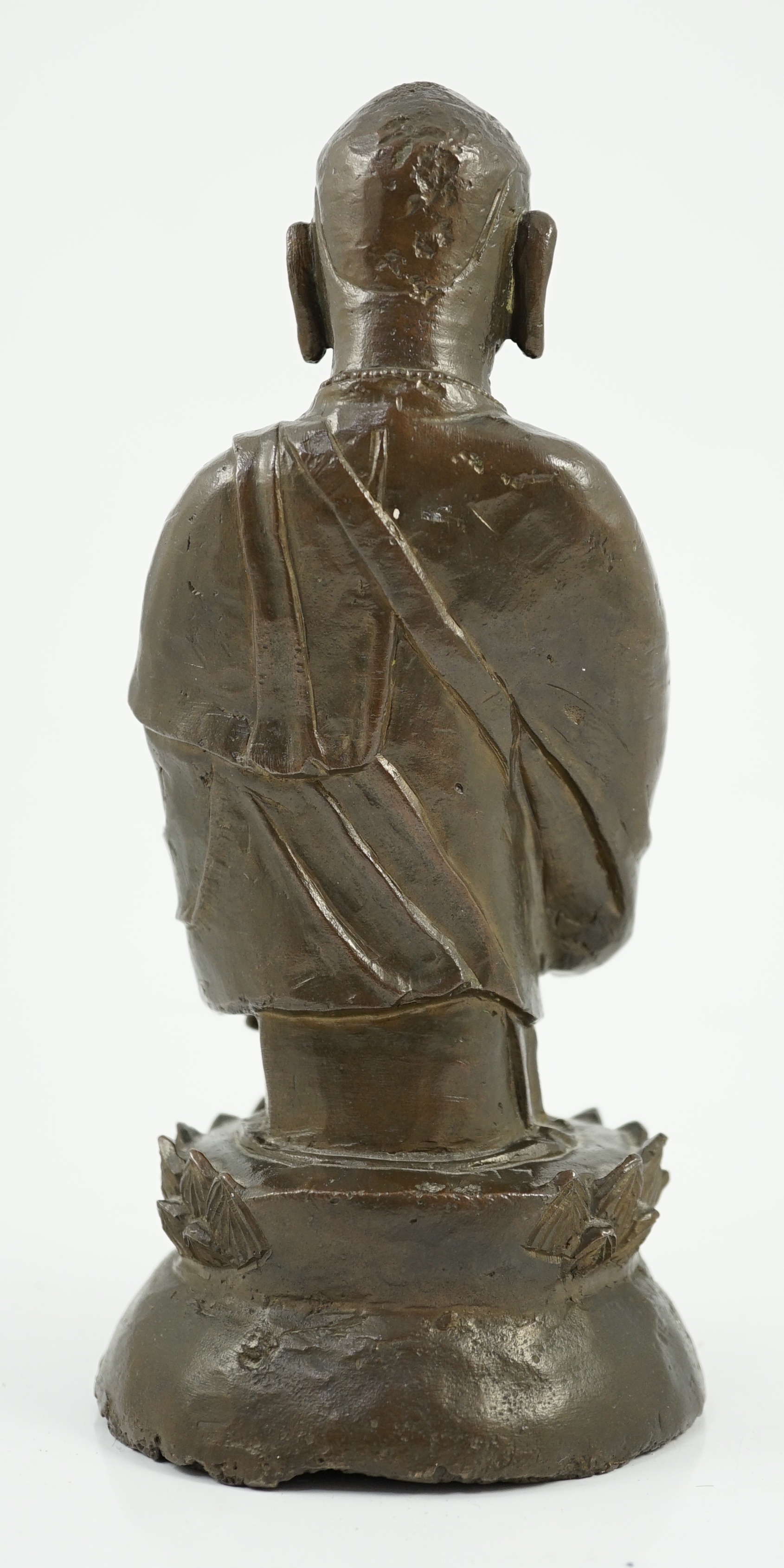 A Chinese bronze figure of a standing luohan, late Ming dynasty, some dents